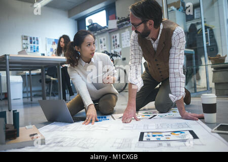 Executives discussing over blueprint Stock Photo