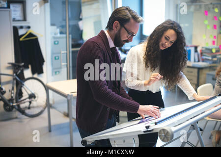 Executives discussing over blueprint Stock Photo