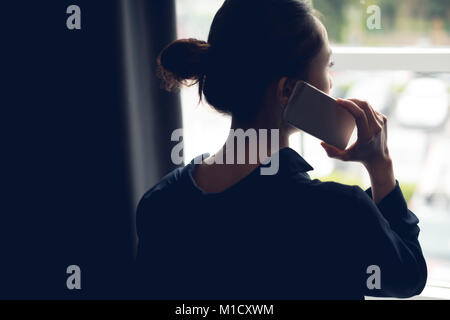 Rear view of woman talking on mobile phone Stock Photo