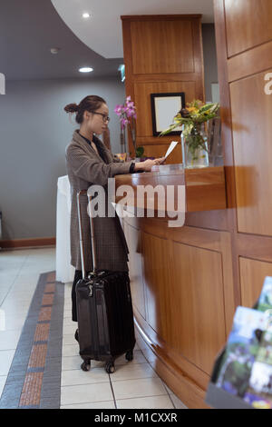 Woman reading document at reception area Stock Photo