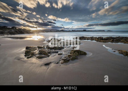 spectacular sunset on the beach of Arnao, Asturias, photographing the different colors, shapes and textures of the clouds, reflected in the fine sand.. Stock Photo