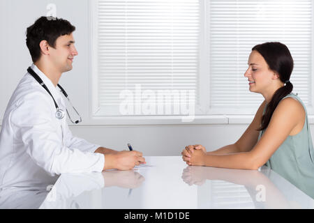 Male Doctor Giving Prescription To Sick Patient In Hospital Stock Photo