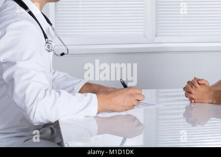 Close-up Of A Doctor Writing Prescription For Patient In Hospital Stock Photo