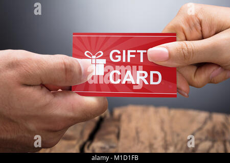 Close-up Photo Of Hands Exchanging Gift Card Stock Photo