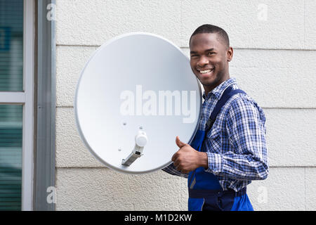 Happy Male Technician With TV Satellite Dish Stock Photo - Alamy