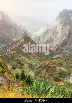 Mountain peaks in Xo-Xo valley of Santa Antao island in Cape Verde. Landscape of many cultivated plants in the valley between high rocks. Arid and erosion mountain peaks under hot sun light Stock Photo