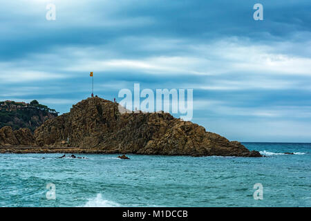 The rock Sa Palomera with the national flag of Spain at the top (Spain, Blanes) Stock Photo
