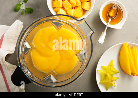 Making smoothie with frozen mango Stock Photo