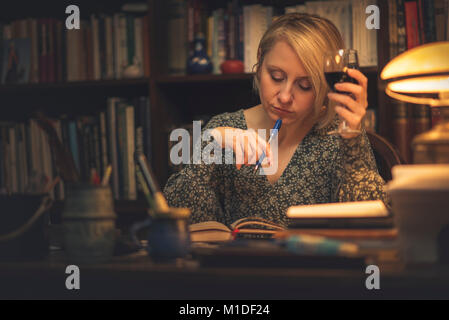 Writing a book in a personal library Stock Photo