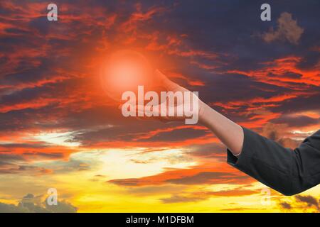business man receiving hand holding the light in  palm of  idea  on sky red  background Stock Photo