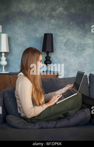 Cute Woman Working at Home Office and Using Laptop. Internet Surfing and Social Media Concept Stock Photo