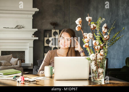 Cheerful Woman Using Laptop at Home Office Stock Photo