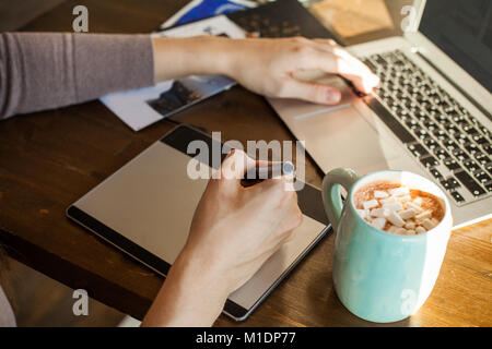 Designer Using Graphic Tablet and Laptop  at Home Office Stock Photo