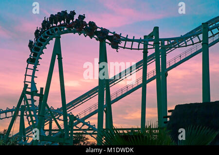 Isla Magica (Magic Island) Theme Park, The Jaguar at sunset - roller coaster (and people upside), Seville, Region of Andalusia, Spain, Europe Stock Photo