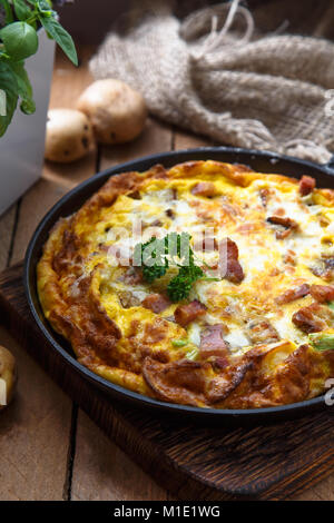 Baked omelette with bacon and cheese in a pan, close view Stock Photo