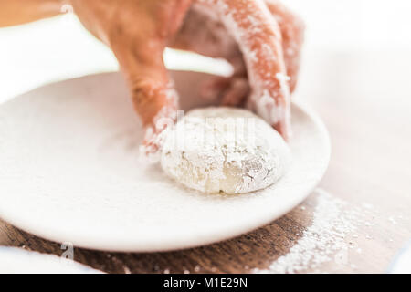 Hands shaping piece of mochi sticky glutinous rice cake dusted with starch flour to make dessert Stock Photo