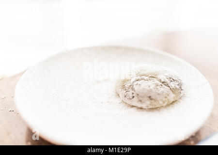 Hands shaping piece of mochi sticky glutinous rice cake dusted with starch flour to make dessert Stock Photo