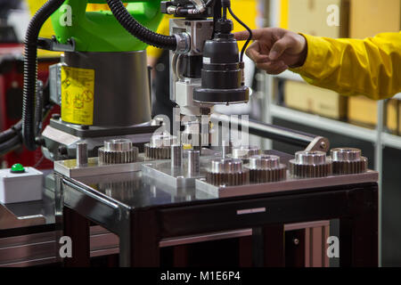 Worker operating 2D sensor robotic assembly machine Stock Photo
