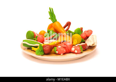 plasticine vegetables and fruits on a plate on a white background Stock Photo