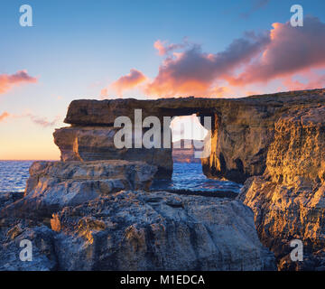 Azure window, natural stone arch by Dwejra cliff, Gozo island, Malta on a sunset. The arch had recently collapsed into the sea during storm. This pict Stock Photo