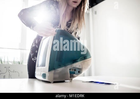 A member of staff shows iMac G3, release date August 1998, at MacPaw's Ukrainian Apple Museum in Kiev, Ukraine on January 26, 2017. Ukrainian developer MacPaw has opened Apple hardware museum at the company’s office in Kiev. The collection has more than 70 original Macintosh models dated from 1981 to 2017. Stock Photo