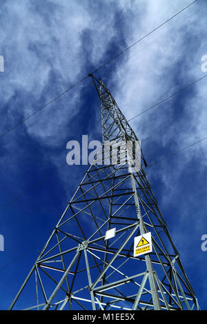 Peligro / Danger sign in Spanish on electricity pylon against blue sky, Bolivia Stock Photo