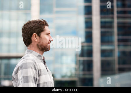 Profile of a young man standing alone in the city Stock Photo