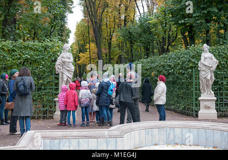 SAINT - PETERSBURG, RUSSIA - OCTOBER 15, 2017: People have excursion near ancient statues in The Summer Garden Stock Photo