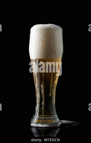 Wet full beer glass stand isolated on black background Stock Photo
