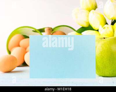 Happy Easter background tulips flowers eggs green apples. Green pastel backdrop spring color blank greeting card Stock Photo