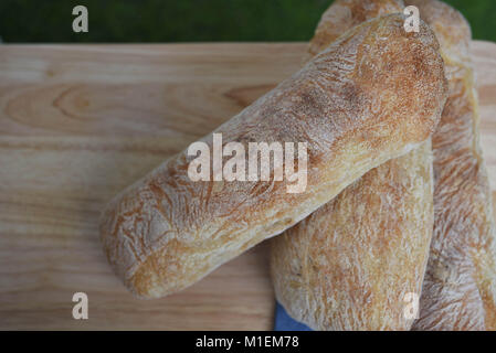 rustic food of homemade artisan ciabatta white bread placed on a natural wood cutting board  with overhead view Stock Photo