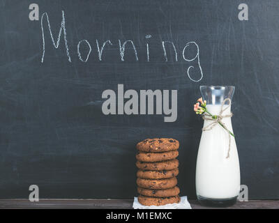 Jug of fresh milk and a fragrant cookies with chunks of chocolate, chalkboard with the inscription MORNING Stock Photo