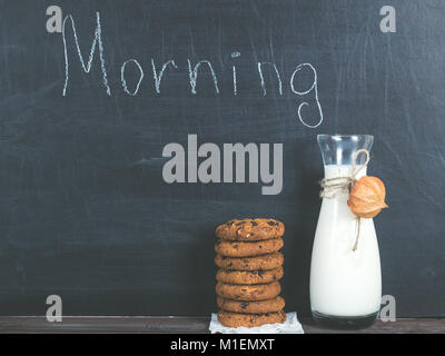 Jug of fresh milk and a fragrant cookies with chunks of chocolate, chalkboard with the inscription MORNING Stock Photo