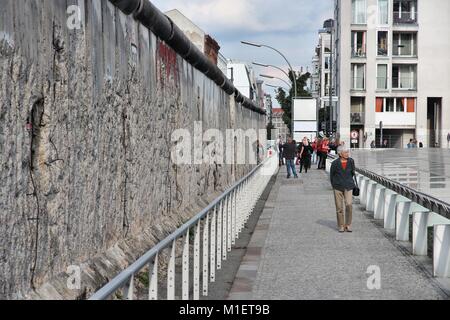 BERLIN, GERMANY - AUGUST 26, 2014: People visit historical Berlin Wall. Berlin Wall was a historical barrier that existed from 1961 through 1989. Stock Photo