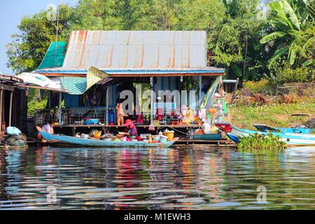 TONLE SAP, CAMBODIA - DECEMBER 11, 2013: Unidentified people go about their daily life in floating village on Tonle Sap lake. It is the largest lake i Stock Photo