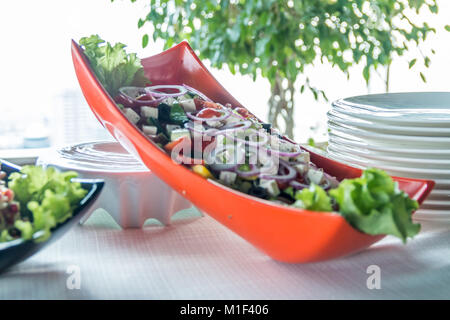 Salad with sausage, greens and other on table with white table. Catering concept. Stock Photo