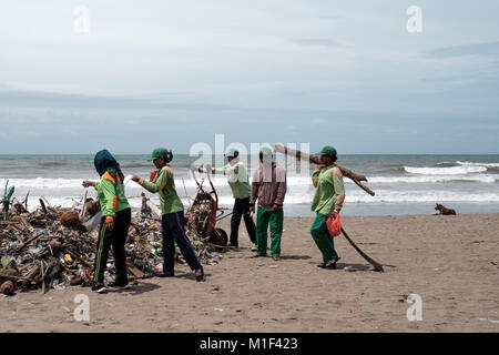 Kuta, BALI INDONESIA - January 27, 2018 People collecting garbage on the beach. Pollution on the beach of tropical sea in Bali, Indonesia Stock Photo