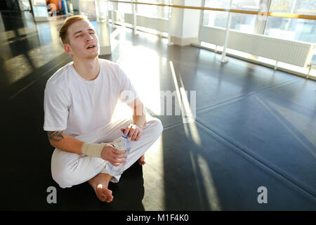 Guy doing drinking water before morning training.  Stock Photo