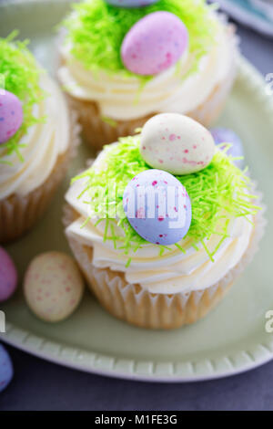 Easter vanilla cupcakes with cream cheese frosting and egg candy Stock Photo