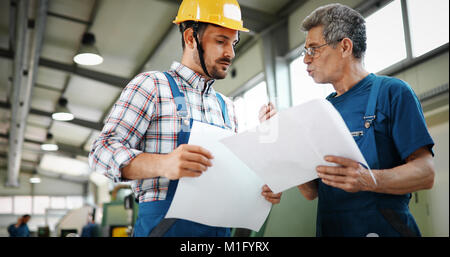 Engineer Teaching Apprentices To Use Computerized cnc metal processing machines Stock Photo