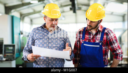 Engineer Teaching Apprentices To Use Computerized cnc metal processing machines Stock Photo