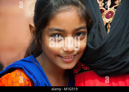 Young and beautiful shy girl with her mother outside the Red Fort in Rakabganj, Agra, Uttar Pradesh, India Stock Photo