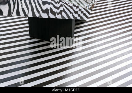 Geometric pattern of black and white floor stripes and mirrored escalator. Stock Photo
