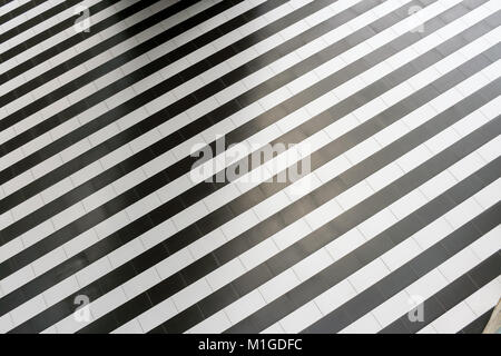 Abstract geometric pattern of regular alternating black and white stripes on the floor. Stock Photo