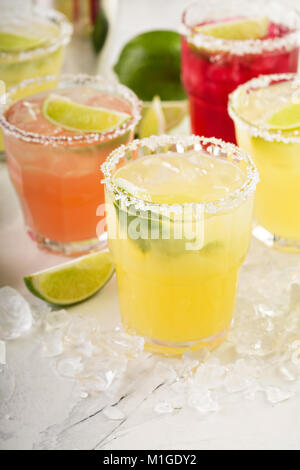 Variety of margarita cocktails with salted rim and lime on white background Stock Photo