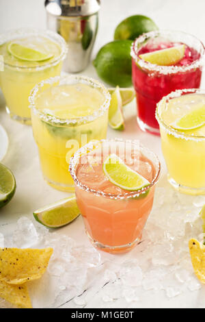 Variety of margarita cocktails with salted rim and lime on white background Stock Photo
