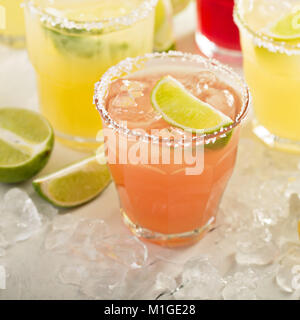 Variety of margarita cocktails with salted rim and lime on white background Stock Photo