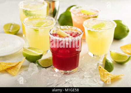 Variety of margarita cocktails with salted rim and lime on white background Stock Photo