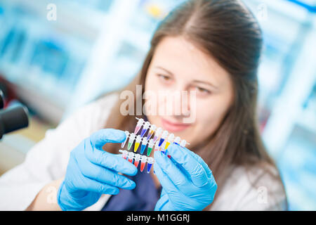 Young female technician in genetic laboratory with PCR Stock Photo