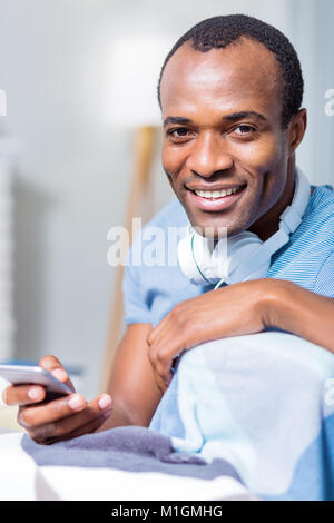 Nice delighted man using his device Stock Photo